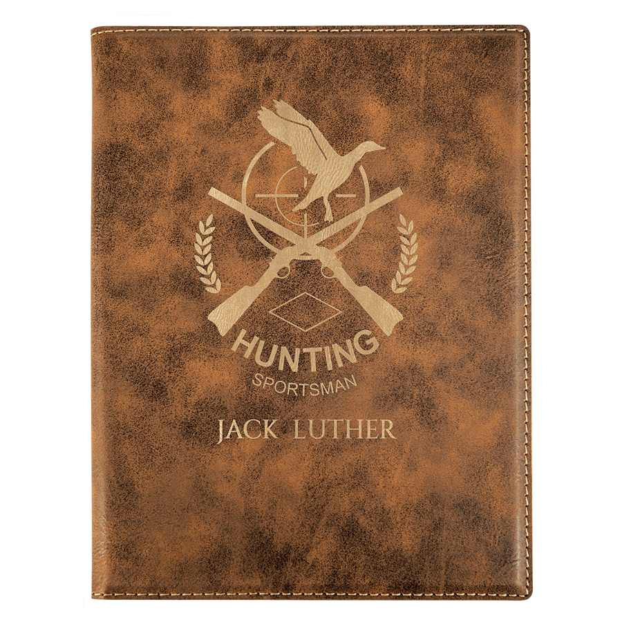 Brown leather notebook with hunting-themed design and engraved text on a white background