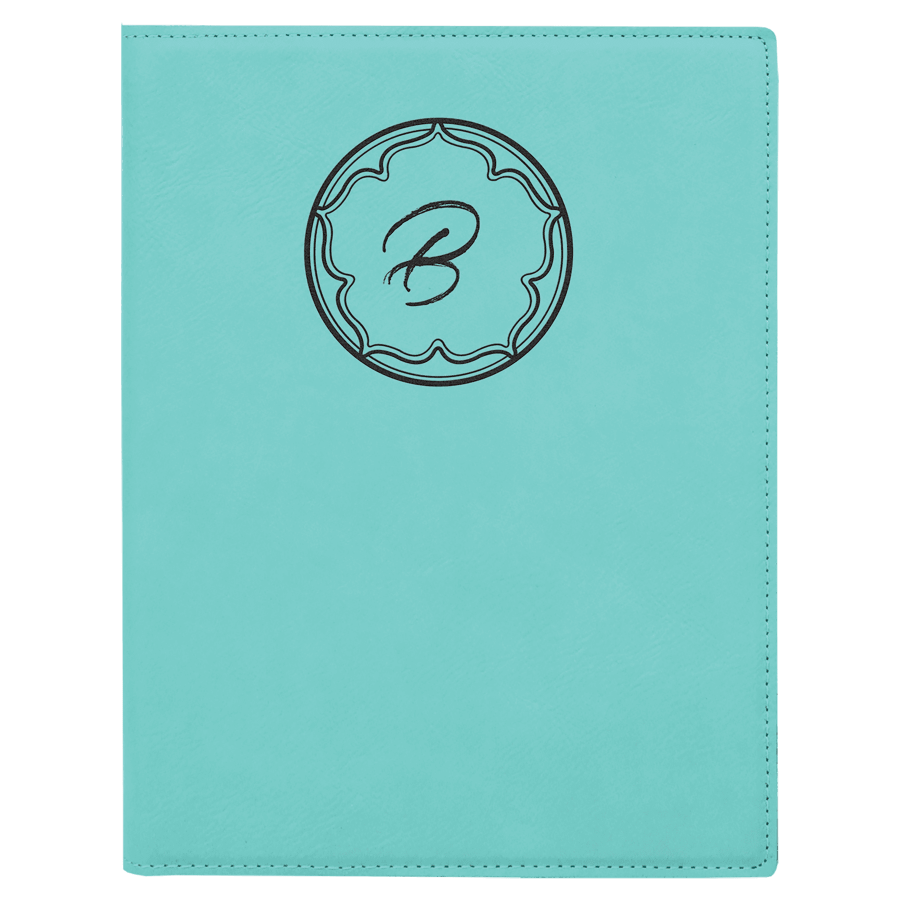Teal notebook with a decorative monogram on a teal background