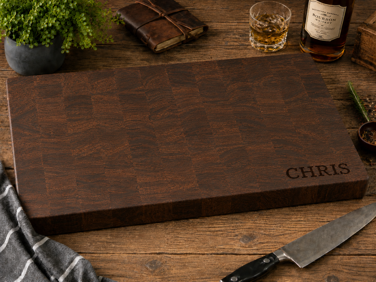Wooden cutting board with 'CHRIS' engraving on a wooden table with a knife and glass.