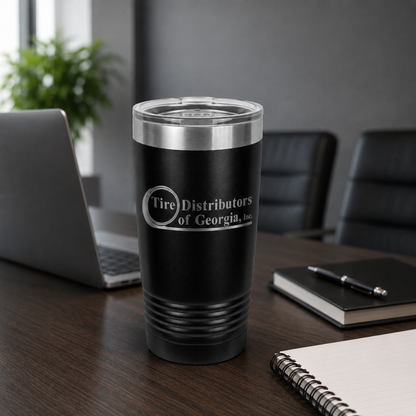 Black tumbler with 'Tire Distributors of Georgia, Inc.' logo on a desk in an office setting.