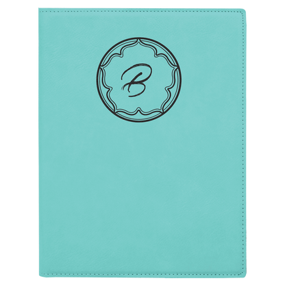 Teal notebook with a decorative monogram on a teal background